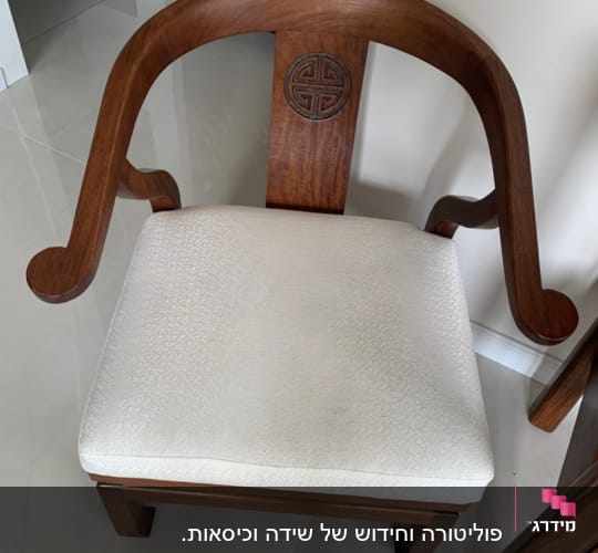 כיסא עץ עם ריפוד בהיר ודוגמה מעוגלת בגב